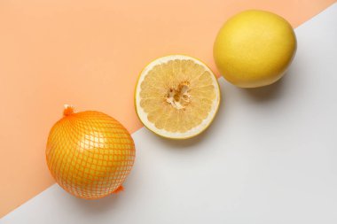 Renkli arka planda tüm ve tatlı pomelos kesim