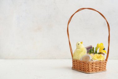 Dekoratif kozmetik ürünleri, beyaz arka planda bebek tavuk ve çiçeklerle dolu bir sepet.