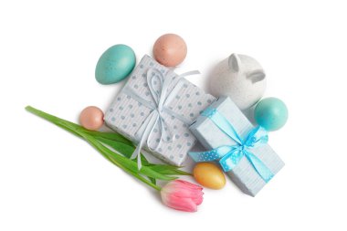 Paskalya yumurtaları, tavşan figürü, lale ve beyaz arka planda hediyeler.