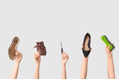 Ayakkabı parçalı kadın elleri, el işi aletleri ve beyaz arka planda fırçalar. Ayakkabı tamir konsepti