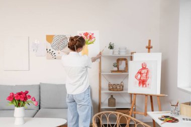 Atölyede resim yapan kadın sanatçı, arka plan