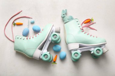 Paskalya yumurtaları, oyuncak tavşanlar ve beyaz arka planda havuçlarla klasik patenler.