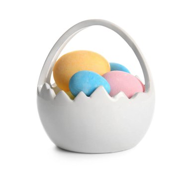 Beyaz zemin üzerinde boyanmış Paskalya yumurtaları olan seramik sepet.