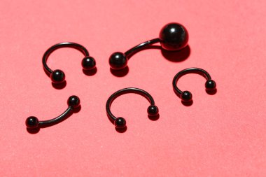 Kırmızı arkaplanda delmek için siyah halterler.