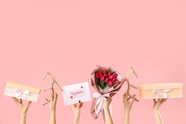 Lale buketli kadın elleri, yüksek topuklu ayakkabılar ve pembe arka planda hediye kutuları. Uluslararası Kadınlar Günü için Alışveriş