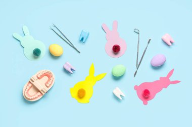 Dişçi aletleri, paskalya yumurtaları ve arka planda kağıt tavşanlarla kompozisyon