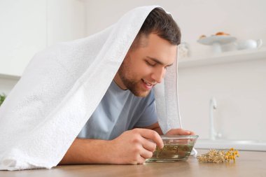 Genç adam mutfakta buhar solumuş.