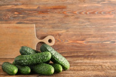 Ahşap arka planda bir yığın taze salatalık.