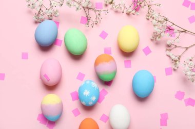 Boyalı Paskalya yumurtaları, çingene çiçekleri ve pembe arka planda konfeti ile kompozisyon