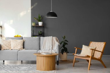 Konforlu kanepesi, koltuğu, çiçekleri ve masası olan modern oturma odasının güzel iç mekanı.