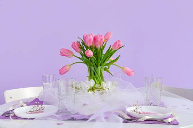 Uluslararası Kadınlar Günü kutlamaları için renkli duvarın yanında güzel lale çiçekleri olan masa ayarı