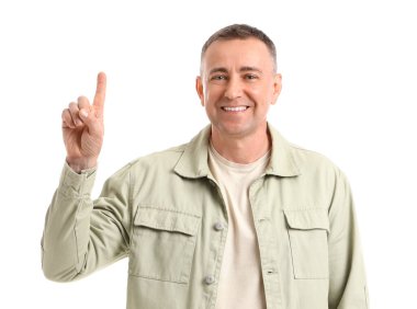 Olgun adam beyaz arka plandaki bir şeyi işaret ediyor.