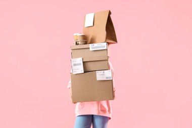 Pembe arka planda paketleri ve yiyeceği olan kadın kurye.