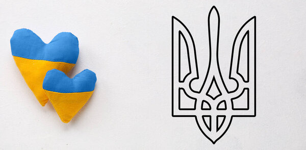 Hearts in colors of Ukrainian flag and coat of arms on light background
