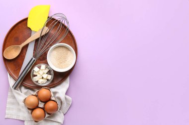 Leylak arkaplanı üzerine fırın hazırlamak için malzemeler ve çatallar içeren kompozisyon