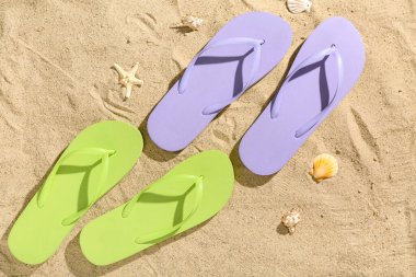 Kumlu arka planda renkli parmak arası terlikler