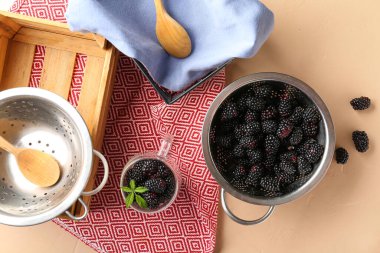 Turuncu arka planda taze böğürtlenli kolatör ve cam bardak
