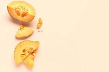 Tatlı kavun parçaları ve pembe arka planda tohumlar.