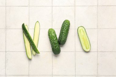 Beyaz fayans zemininde taze salatalıklar