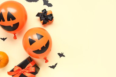 Komik cadılar bayramı turuncu balonları hediye kutuları ve sarı arka planda kağıt sopalarla