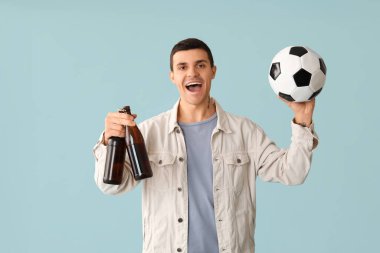 Mavi arka planda bira şişeleri ve futbol topuyla yakışıklı bir genç.