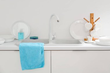 Mutfakta lavabonun yanındaki masada temiz tabaklar var.