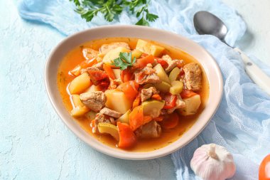 Lezzetli biftek güveci ve açık mavi arka planda maydanoz.