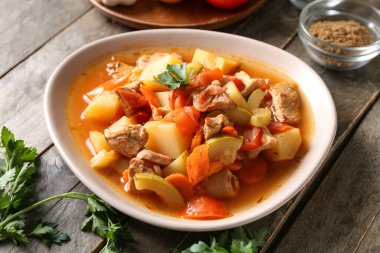 Lezzetli biftek güveci ve ahşap arka planda maydanoz.