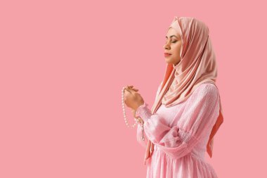 Pembe arka planda dua eden boncuklu güzel Müslüman kadın.