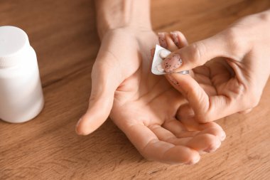 Olgun bir kadın su toplayıcıdan hap alıyor, yakın plan.