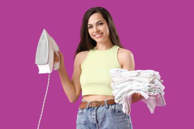 Mor arka planda demir ve temiz giysileri olan güzel bir kadın.