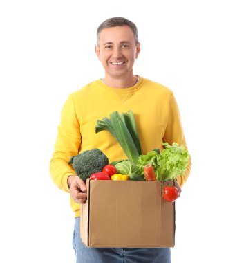 Beyaz arka planda bir kutu taze sebzeli olgun adam.