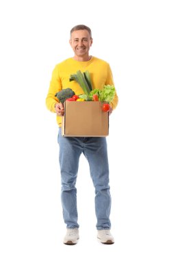 Beyaz arka planda bir kutu taze sebzeli olgun adam.