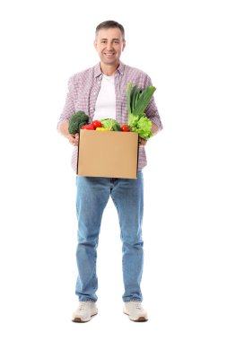 Beyaz arka planda bir kutu taze sebzeli olgun adam.