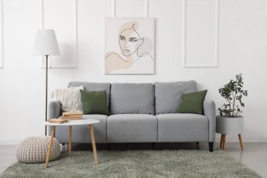 Rahat bir kanepe ve beyaz duvarın yanındaki masa.