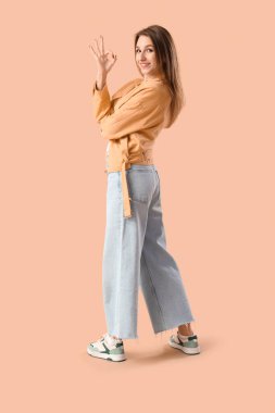 Genç bayan kahverengi arka planda iyi görünüyor.