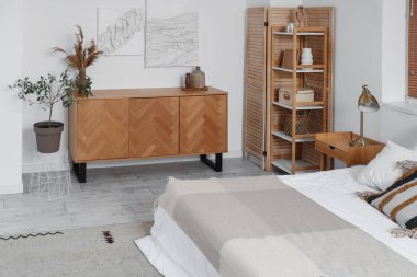 Tabloları, tuvaleti ve raf ünitesi olan şık bir yatak odası.