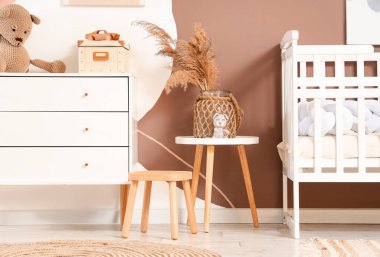 Çimenli vazo ve oyuncak çocukların yatak odasındaki masada.