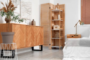 Tabloları, tuvaleti ve raf ünitesi olan şık bir yatak odası.