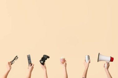 Ellerinde patlamış mısır, içecek, oyun bloknotu ve bej arka planda 3D gözlükler var.