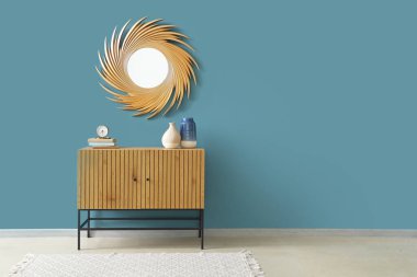 Odadaki mavi duvarda dekorlu ve altın aynalı tuvalet.