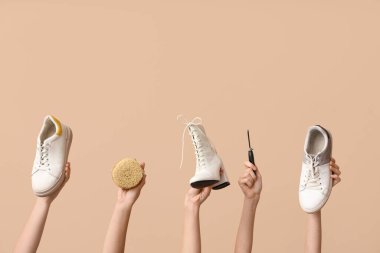Farklı stil ayakkabıları olan kadın elleri, bej arka planda fırça ve el işi aletleri. Ayakkabı tamiri kavramı