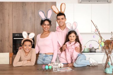 Mutlu aile Paskalya Günü 'nde mutfakta yumurta boyuyor.