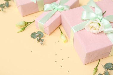 Güzel Eustoma çiçekleriyle hediye kutuları ve sarı arka planda okaliptüs. Uluslararası Kadınlar Günü