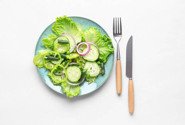 Тарелка вкусного овощного салата на белом фоне