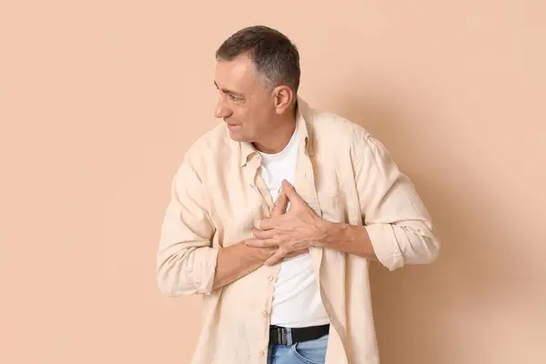 Mature Man Suffering Chest Pain Beige Background — Stock Photo, Image