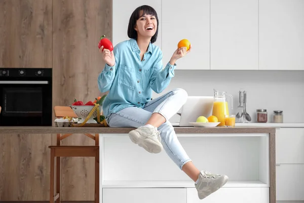 Young woman with healthy food in kitchen. Diet concept
