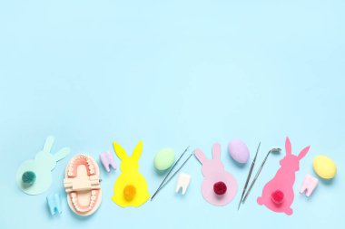 Dişçi aletleri, paskalya yumurtaları ve arka planda kağıt tavşanlarla kompozisyon