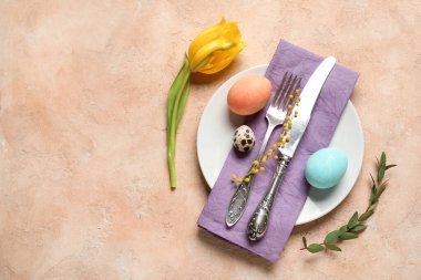 Paskalya yumurtaları ve bej arka planda sarı lale ile güzel bir masa.