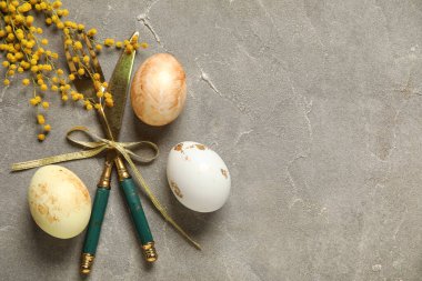 Masa takımı için çatal bıçak takımı ve gri arka planda Paskalya yumurtası.